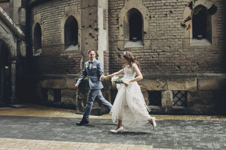 Beautiful emotional wedding couple running and smiling in european city. Provence wedding